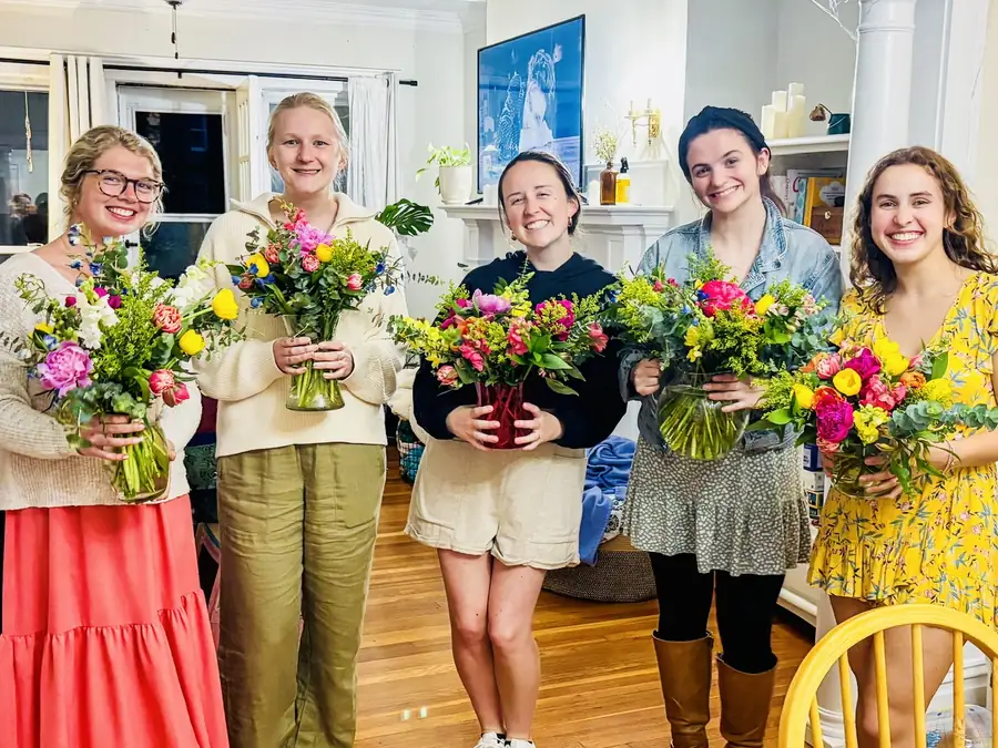 Five guests holding the arrangements they made at a workshop