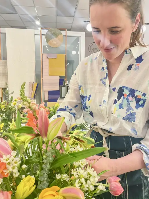 Alba arranging lilies and tulips at a studio table