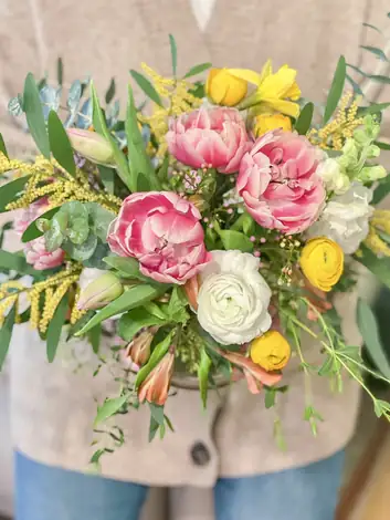 A spring bouquet of tulips, ranunculus and mimosa