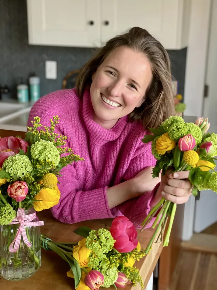 Alba in her kitchen with an armful of spring flowers